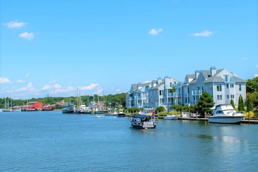 Boat with swaying American flag traveling down Mystic River, Connecticut