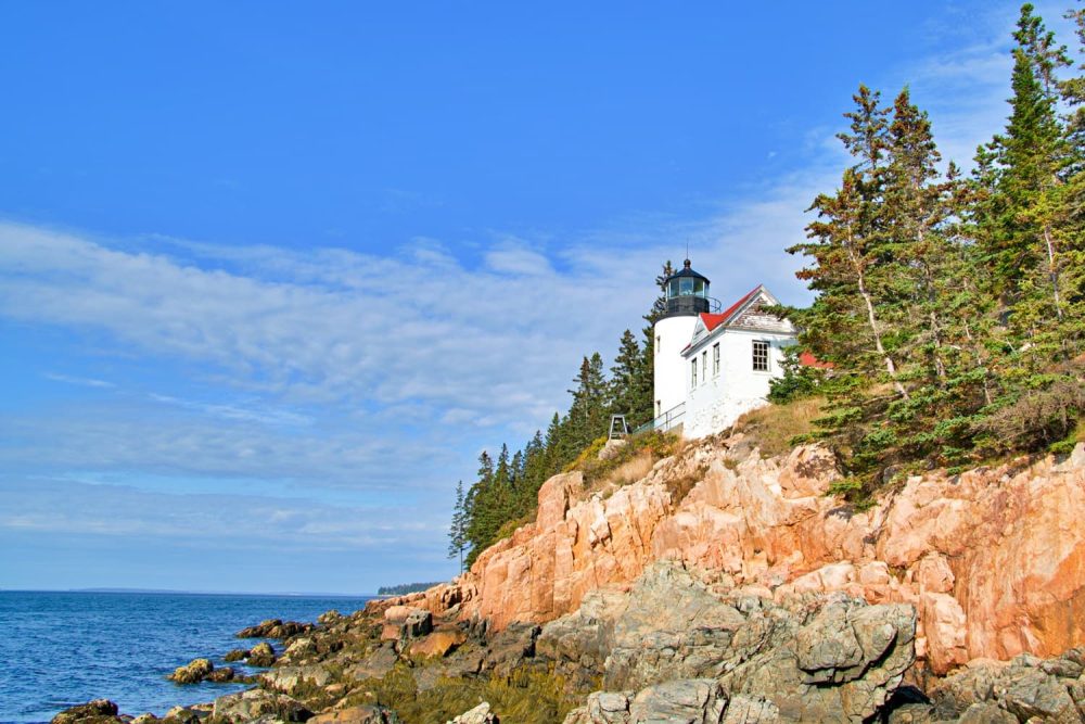Bass Harbor Head Light Station perched on cliffs in orange shades in Acadia National Park