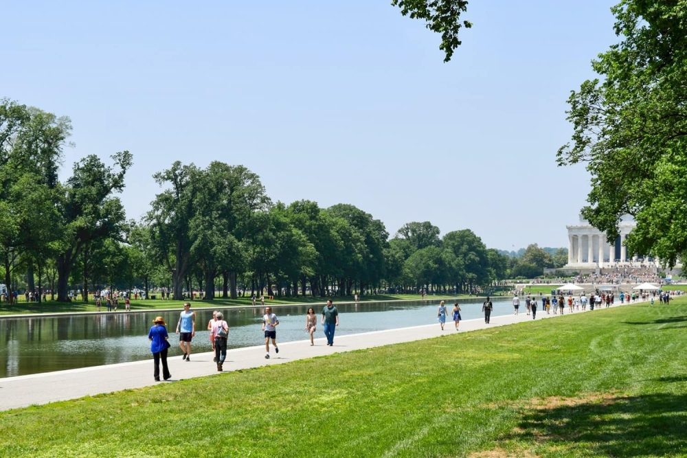 People wandering along the Lincoln Memorial Reflecting Point during a warm day