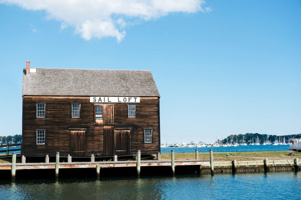 Brown seaside shack by Salem Harbor under a blue sky