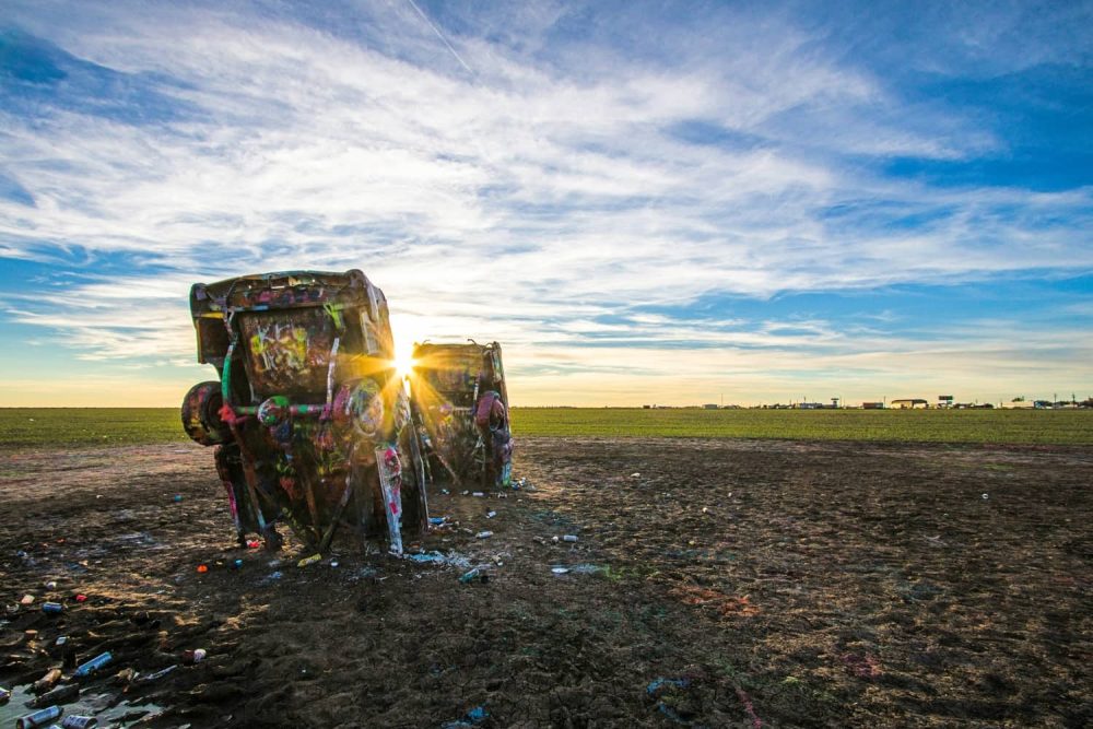 The Cadillac Ranch backdropped by a golden sunset
