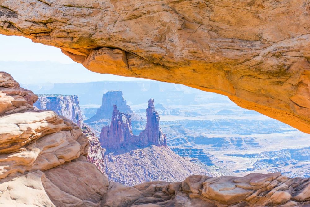 View through the Mesa Arch overlooking the surrounding canyon-like desert landscape